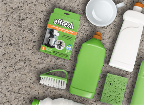 A box of affresh coffee maker cleaner with assorted cleaning supplies.