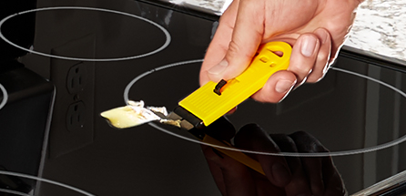 Use the scraper to remove burnt-on food debris from the cooktop.