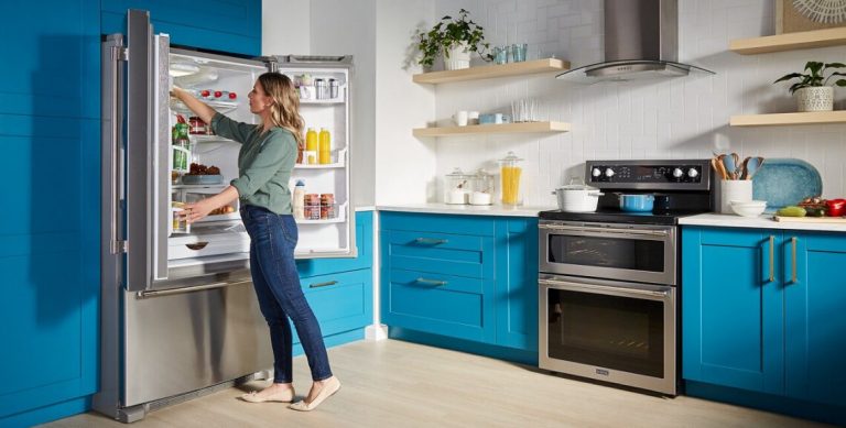 a woman cleans a fridge to help it last longer