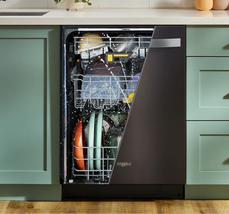 Cutaway view of a Whirlpool dishwasher spraying water over loaded dishes