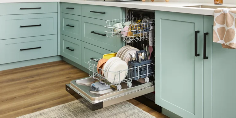 Open dishwasher loaded with plates, bowls, cups, and silverware in a mint-green kitchen
